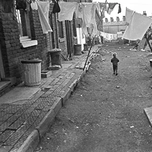 Boy in slum housing yard