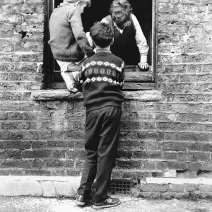 Boys at a boarded up window, Balham, SW London