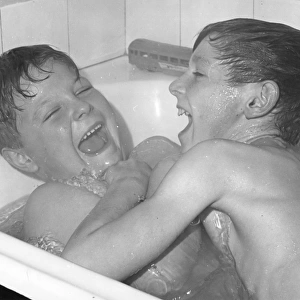 Two boys larking about in the bath