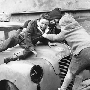 Boys playing on a car in a Balham street, SW London