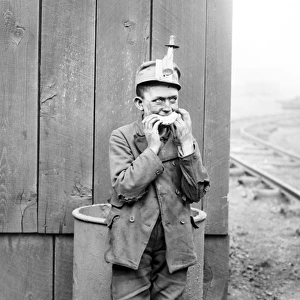 Breaker boy eating during a food break at a coal mine in Kin