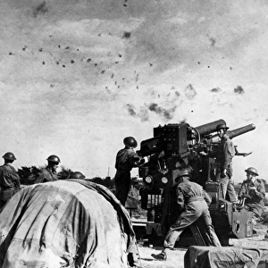 British gunners at work beneath a flak-filled sky, WW2