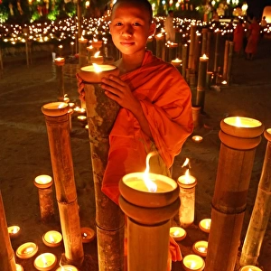 Buddhist Monk at Wat Phan Tao Temple holding candle