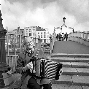 Busker plays an accordian on Ha penny Bridge, Dublin