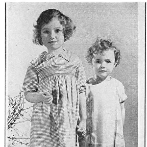 Two child models wearing smocked dresses. Date: 1935