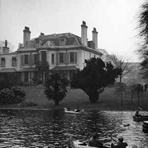 Children canoeing on the boating lake in the grounds of Ravenscourt House, Hammersmith