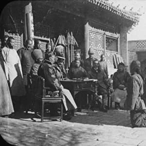 China - 2 men kneeling before a group