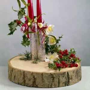 Christmas arrangement of candles, flowers and holly