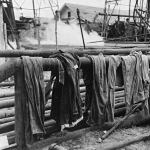 Clothing of oil drilling workers drying on steam pipe, Kilgo