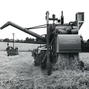 Combine harvester at work in a field, Cornwall