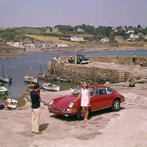Couple with red car at Coverack, Cornwall