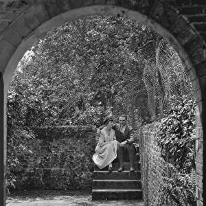 Couple sitting on steps in a garden, Frensham, Surrey
