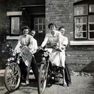 Two couples on two 1930s / 40s Velocette motorcycles outside h
