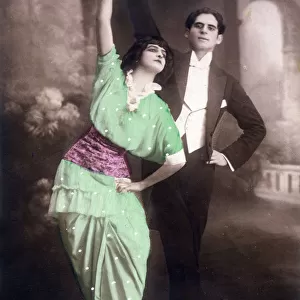 Two dancers pose for the camera with arms aloft... Date: 1914