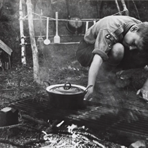 Dutch boy scout cooking at camp, Holland