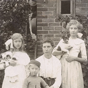 Family of four with a dog and a doll in a garden
