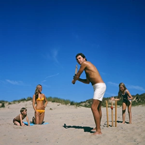 Family playing cricket on the beach, Cornwall