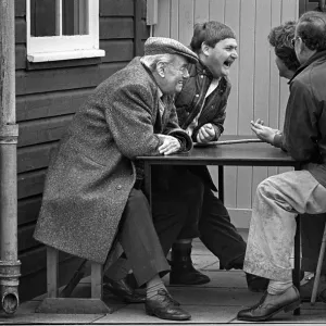 Farmers laugh outside cafe Bury St. Edmunds cattle market