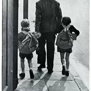 A father leads his two children to be evacuated 1939