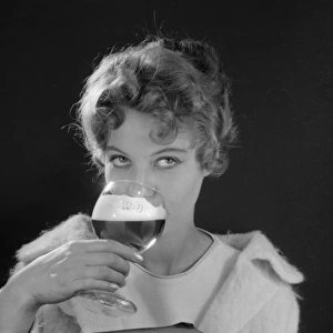Female model (Gillian Watt) holding up a glass of beer