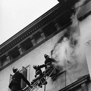 Firefighters in action up a ladder