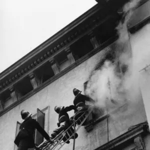 Firefighters in action up a ladder