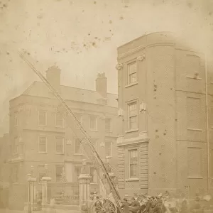 Firefighters in action in a street with a wheeled ladder