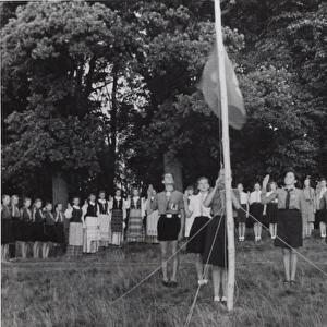 German boy scouts saluting Guide flag at camp