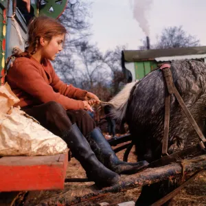 Gipsy girl plaiting horses tail at an encampment in Surrey