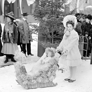 Girl with doll on sleds at the Midwinter carnival children s