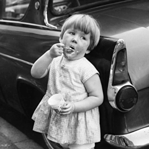 Girl eating ice cream on a Balham street, SW London