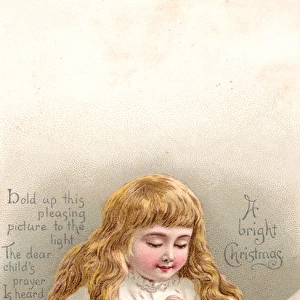 Girl praying by her bed on a Christmas card