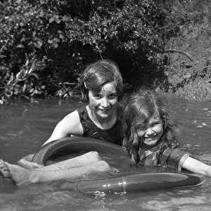Two girls bathing in a stream