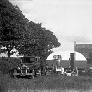 A group of five people having tea outside a caravan