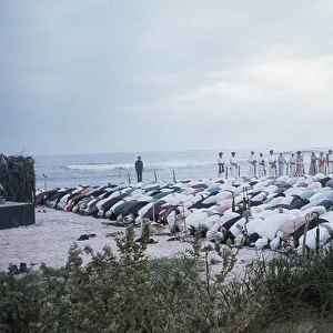 Groups of Omani elders kneel praying in Oman