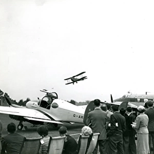 A de Havilland Moth flies past the de Havilland Dove, G-?