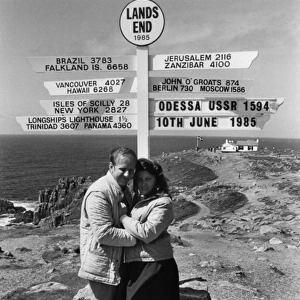 Honeymoon couple and signpost at Lands End, Cornwall