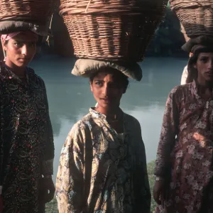 Kashmiri women wearing Kashmiri shirts with baskets of reeds