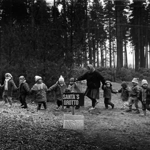 A line of small children are led to Santas grotto A line of small children are led to Santas grotto