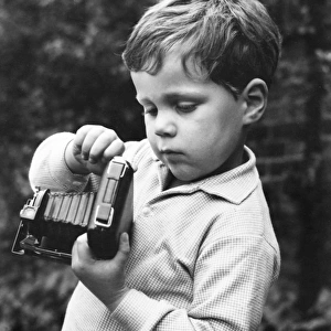 Little boy with a camera in a garden