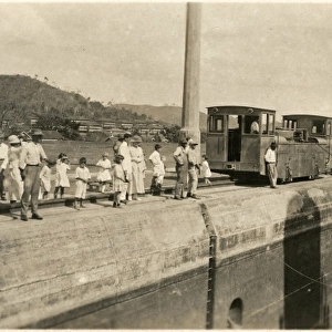 Locals gather along the canal to see the passing of a ship
