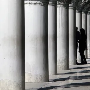 Lovers between marble pillars of the Doges Palace in Venice Lovers between marble pillars of the Doges Palace in Venice