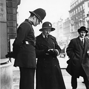 Male and female police officer on a street, London