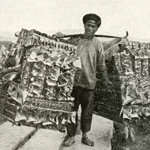 Man carrying imitation paper money, China, East Asia