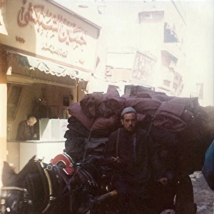 Man driving a Horse and cart with black sacks on a street in