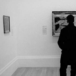 Man looking at a painting in an art gallery