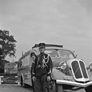 Man in military uniform standing by a coach