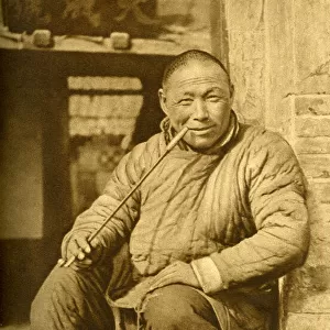 Man relaxing and smoking his pipe, China, East Asia