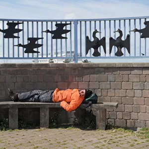 A man sleeps on a bench on Morecambe promenade