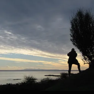 A man takes a photograph of the Isle of Man from Knockbrex A man takes a photograph of the Isle of Man from Knockbrex